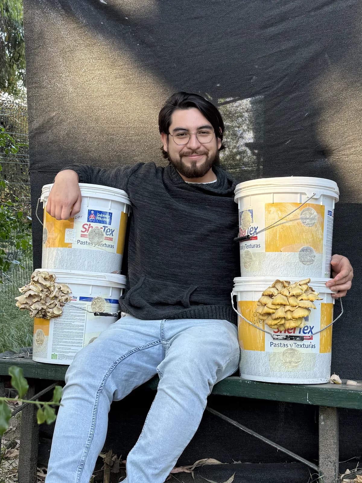 Integrante de Faro mostrando cultivos de hongos comestibles.